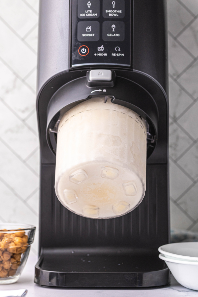 Processing frozen salted caramel mixture in Ninja Creami on Gelato setting.