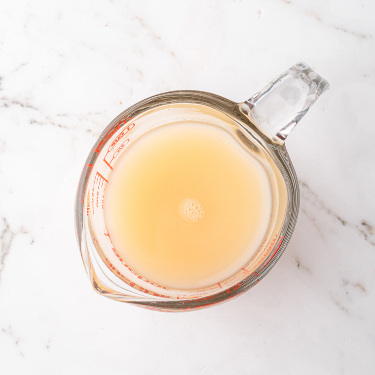 Mixture pouring into a Ninja Slushi machine, blending to icy, slushy consistency.