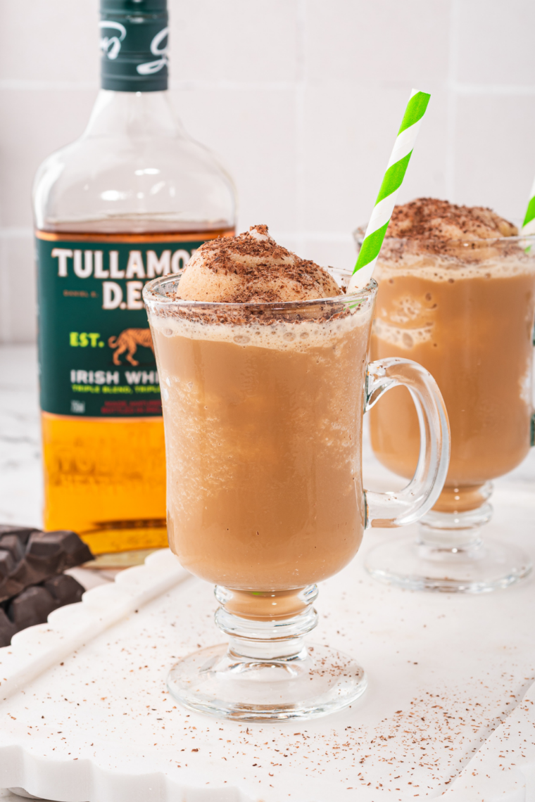 Icy frozen Irish coffee slush in a glass, topped with whipped cream and chocolate shavings, made in a Ninja Slushi machine.