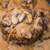 Slow Cooker Salisbury Steak with Cream of Mushroom Soup served on a plate, topped with creamy mushroom gravy and garnished with fresh parsley.