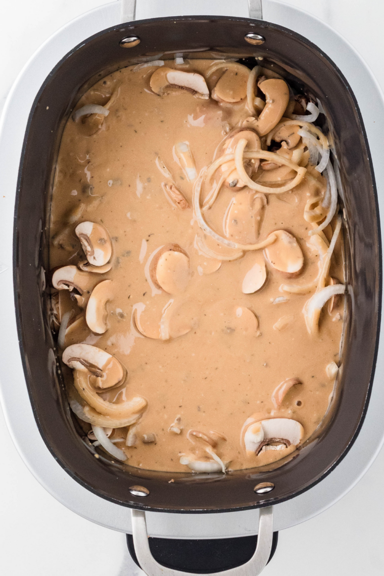 Slow cooker covered and cooking the Salisbury steak patties in rich mushroom gravy.