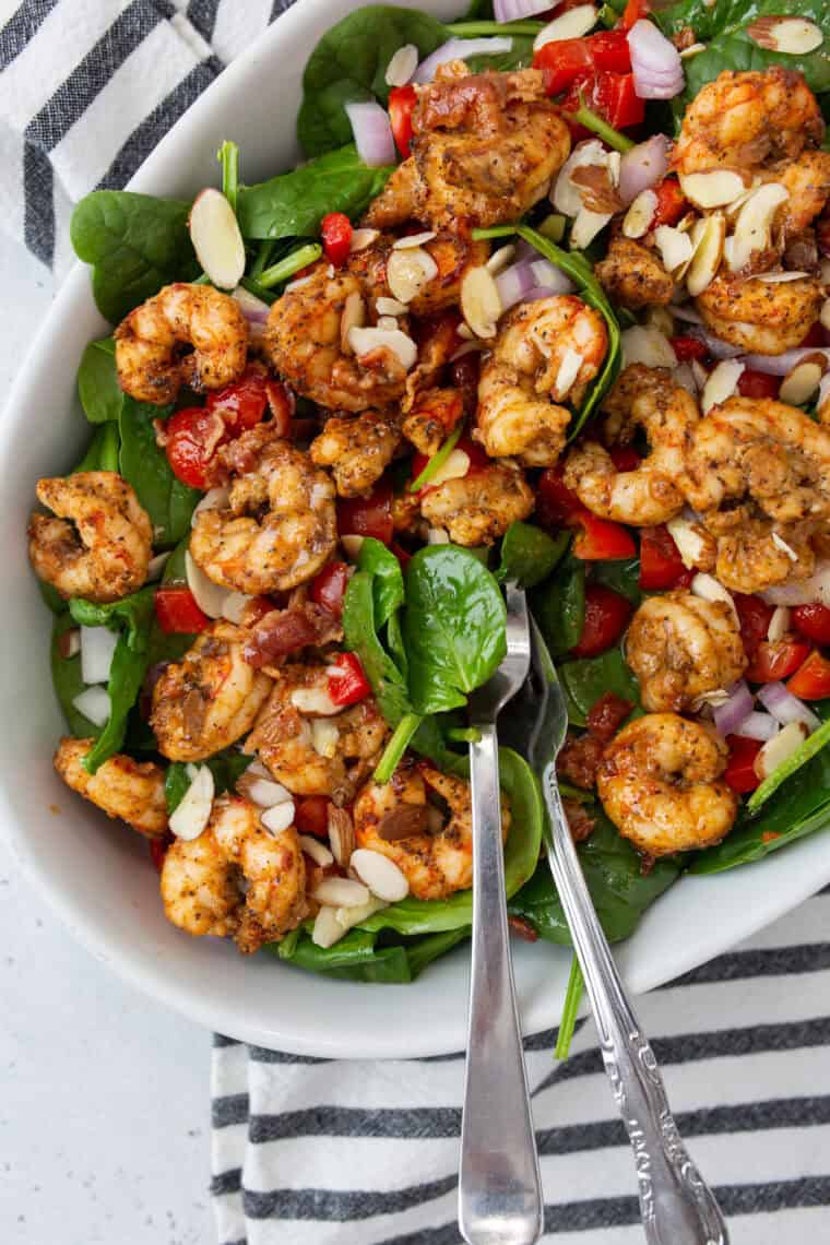 Air fryer shrimp on fresh spinach salad with roasted red peppers and light dressing.