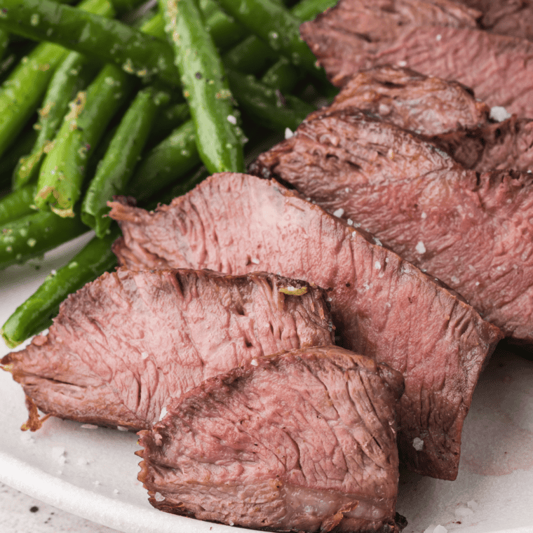 Cooked steak resting on a cutting board before slicing to lock in juices.