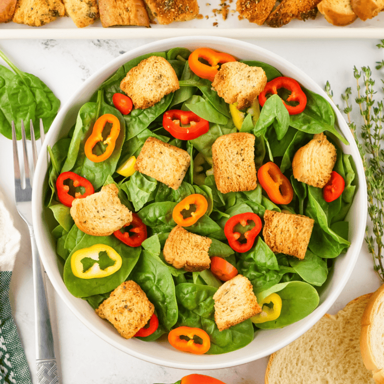 House-style dressing drizzled over salad and tossed, ready to serve as side or appetizer.