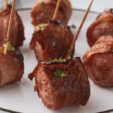 Jar of Copycat Kinder&rsquo;s Hickory Brown Sugar Rub & Seasoning with wooden spoon and spices scattered around.