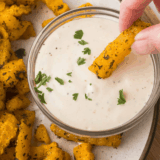 Jar of homemade Copycat Kinder&rsquo;s Sweet Heat Seasoning with a small spoon, showing reddish-brown spice blend.