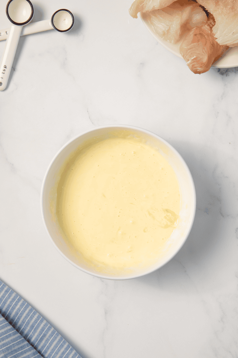 Three bowls with flour, egg and milk mixture, and seasoned panko breadcrumbs for breading station.