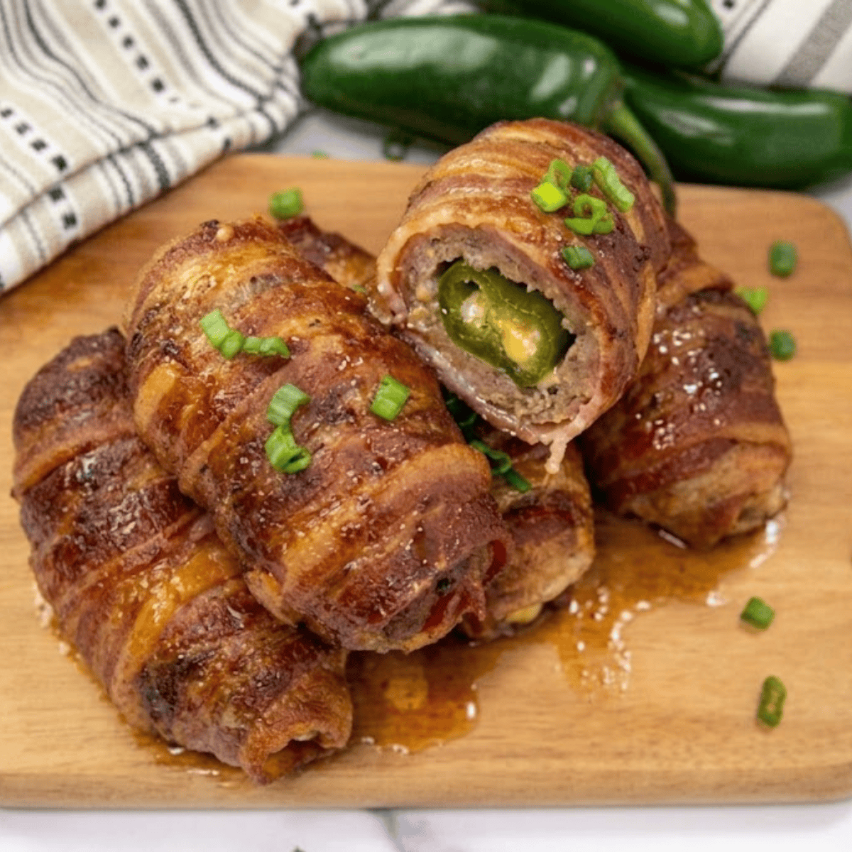 Crispy bacon-wrapped Air Fryer Armadillo Eggs on a plate with melted cheese oozing out.