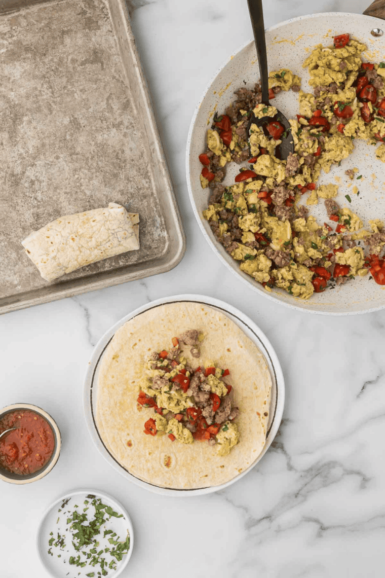 Air Fry the Burritos: Burritos in air fryer basket, sprayed with cooking spray, cooking until golden and crispy.