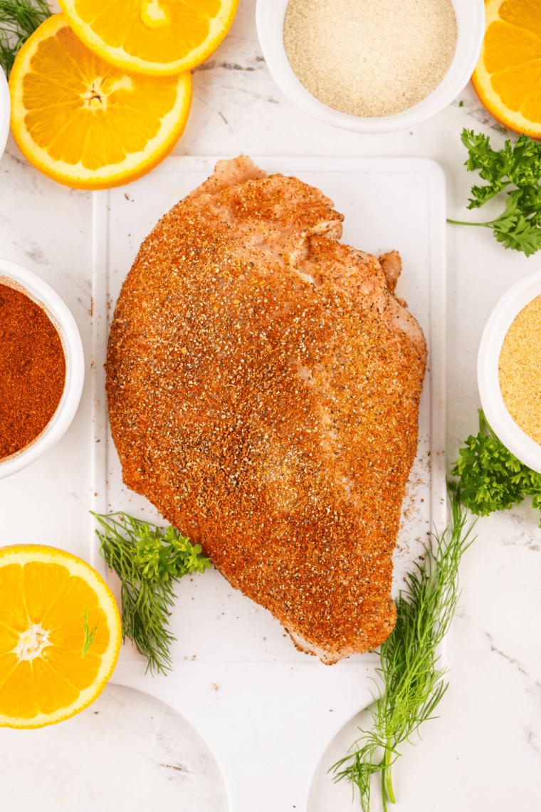 Patting Cajun turkey breast dry with paper towels before seasoning.