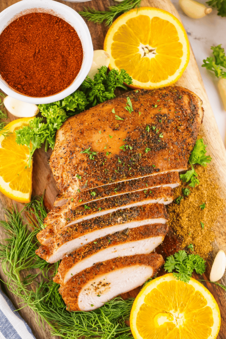 Sliced Cajun Smoked Turkey Breast served on a platter with smoky, golden exterior.