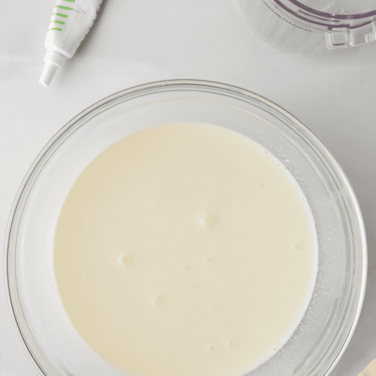 Mixing coconut milk, heavy cream, sugar, and shredded coconut in a bowl until smooth.