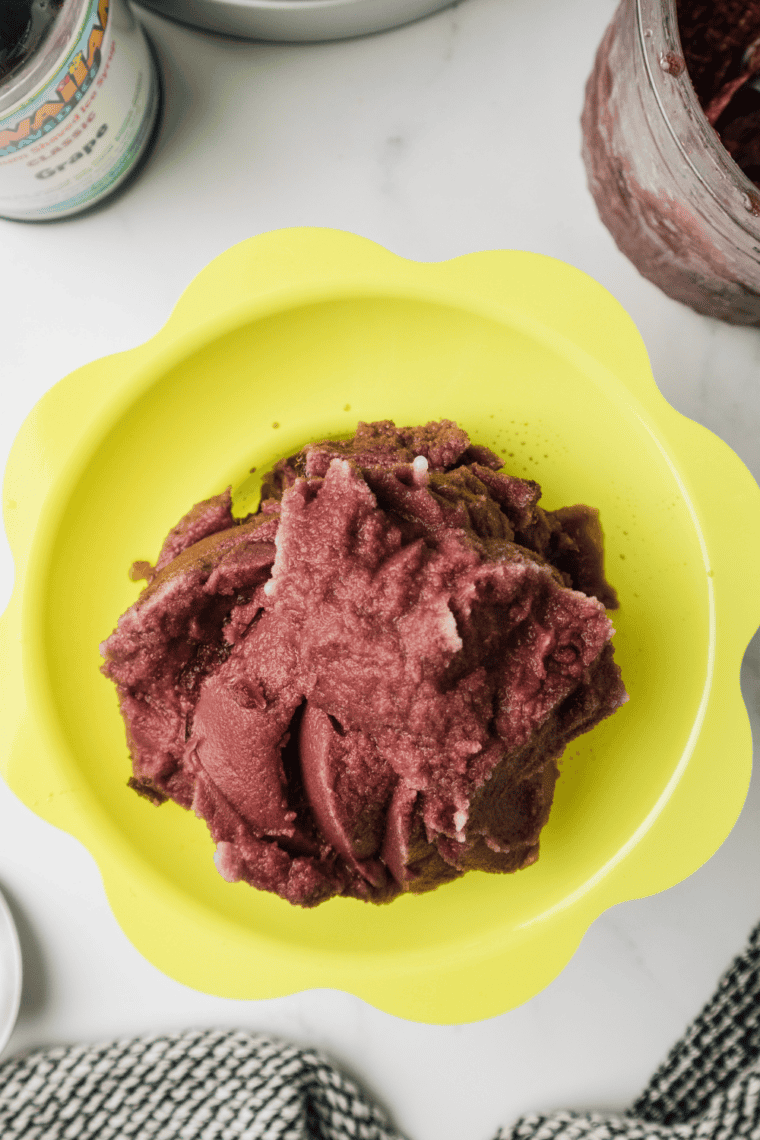 Bowl of bright purple grape Italian ice made in the Ninja Creami, ready to serve
