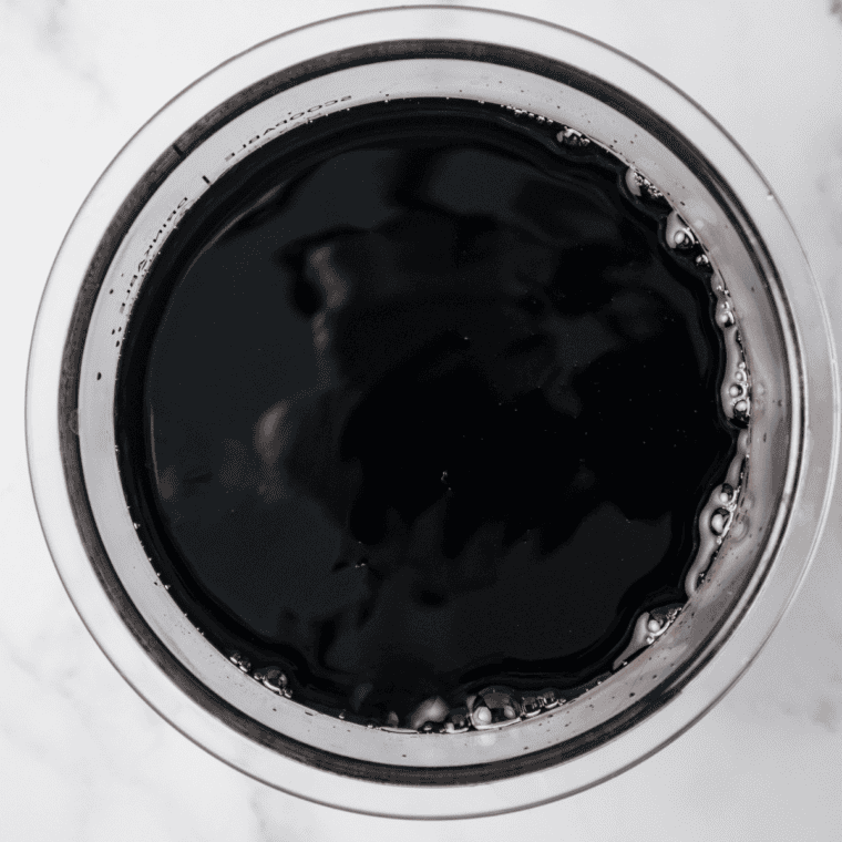 Stirring grape syrup and water together in a mixing bowl until fully blended.