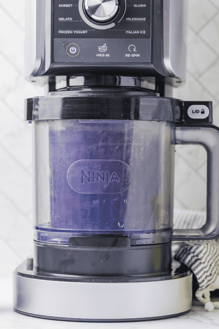 Placing frozen pint in Ninja Creami with Creamerizer&trade; Paddle installed.