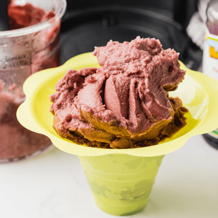 Bowl of bright purple grape Italian ice made in the Ninja Creami, ready to serve