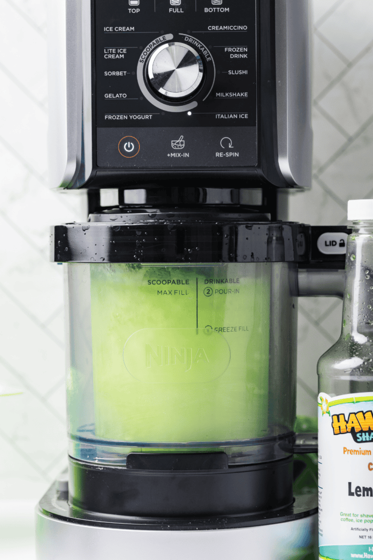 Frozen pint inserted into Ninja Creami machine ready to be processed into Italian ice.