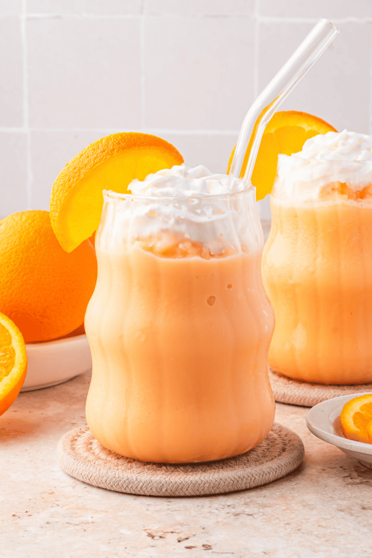 Easy Ninja Slushi Frozen Dirty Orange Soda served in a tall glass with a straw and orange garnish, icy and creamy frozen drink.