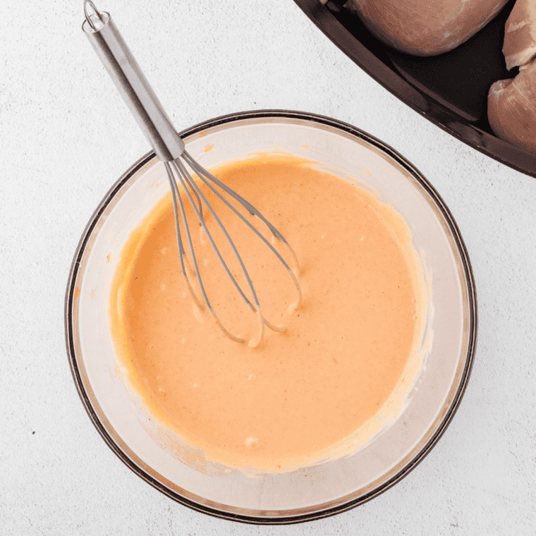 Mixing mayonnaise, sweet chili sauce, sriracha, honey, and garlic powder in bowl.
