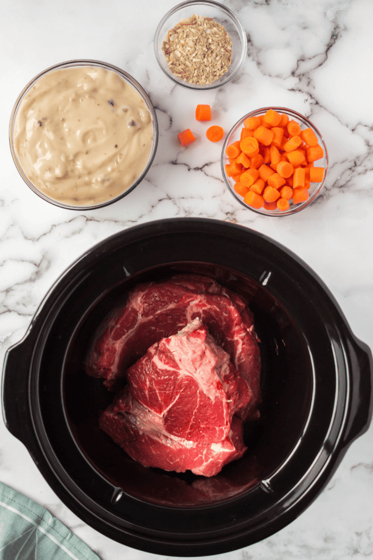 Searing the beef roast in a hot skillet with olive oil until browned.