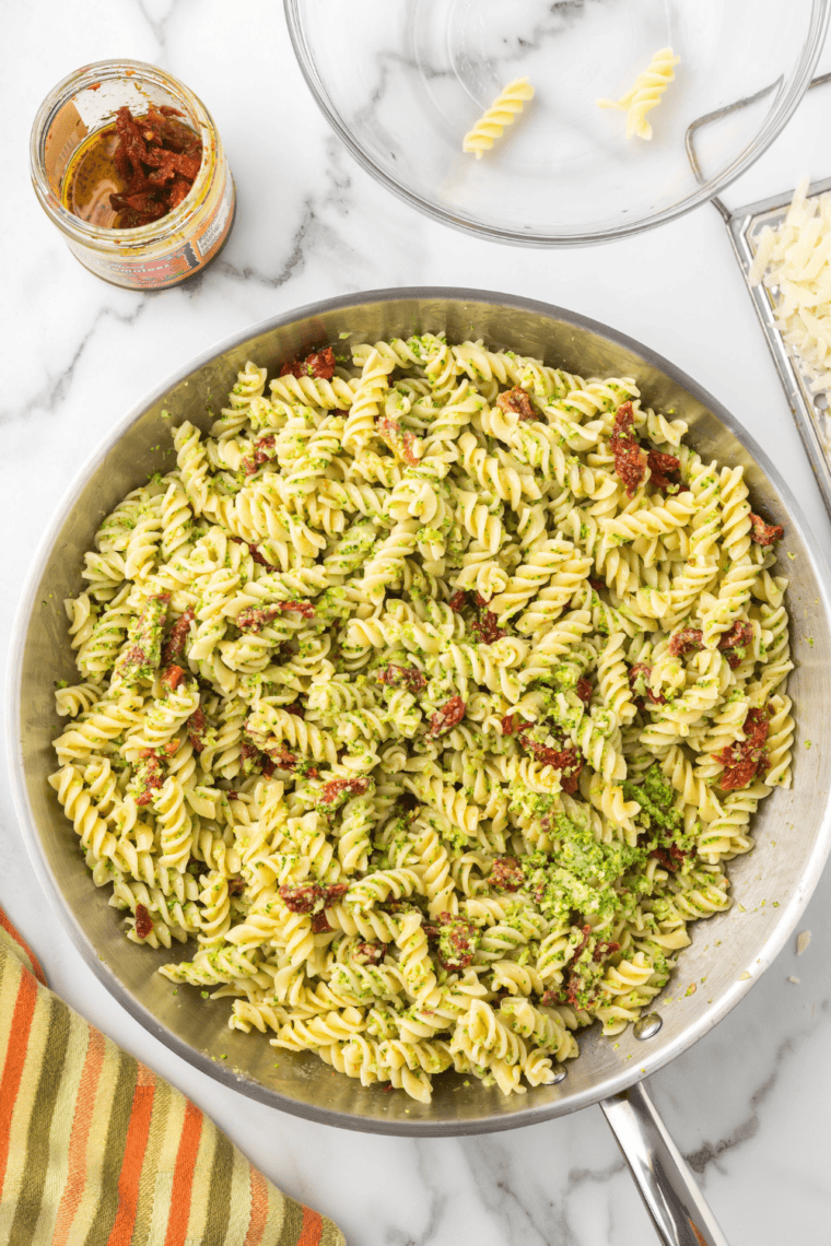 Transferring pasta to air fryer basket, topping with burrata cheese, and melting until creamy.