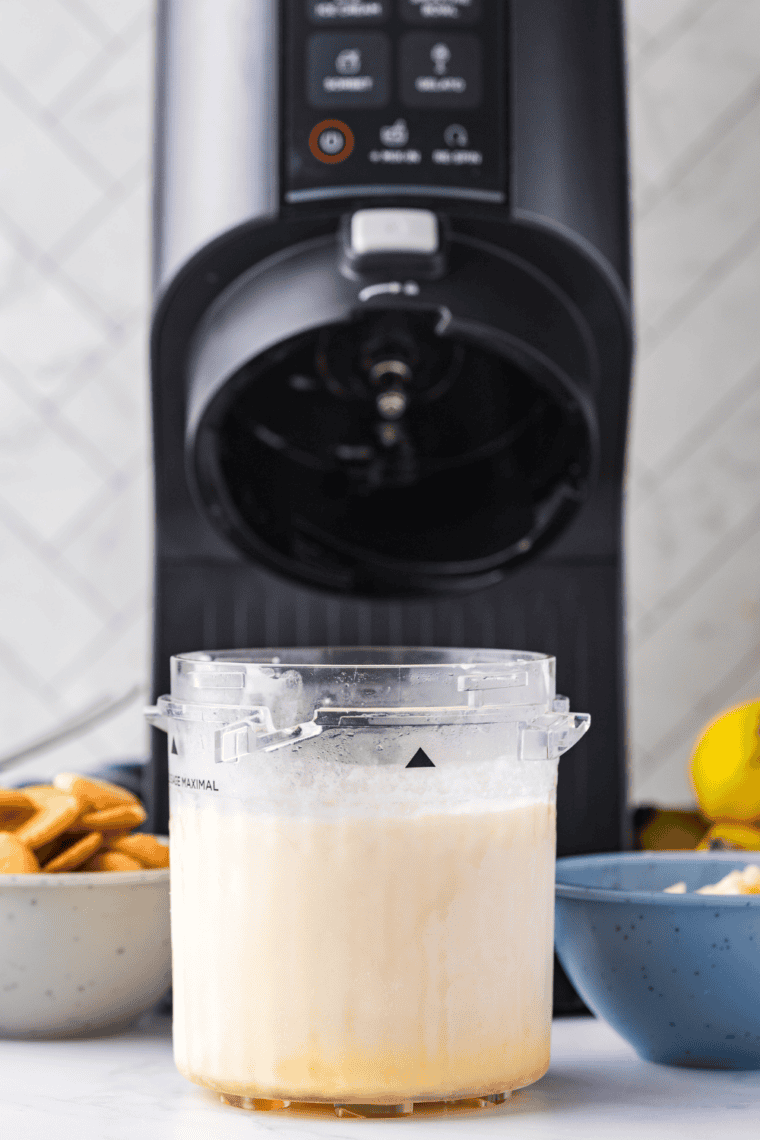 Processing frozen coconut ice cream pint in Ninja Creami machine.