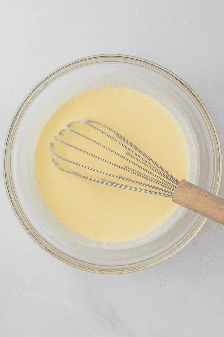 Mixing ice cream base with milk, cream, sugar, and vanilla extract until smooth