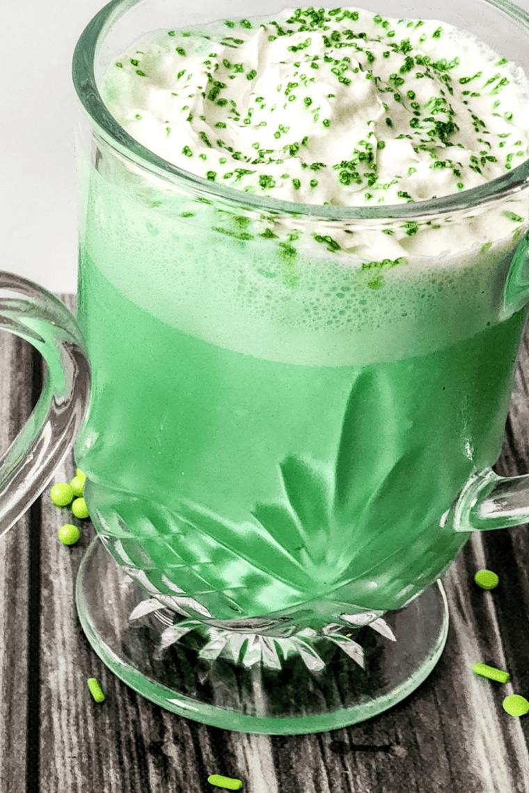Bright green Ninja Slushie Shamrock Shake in a glass topped with whipped cream and sprinkles.