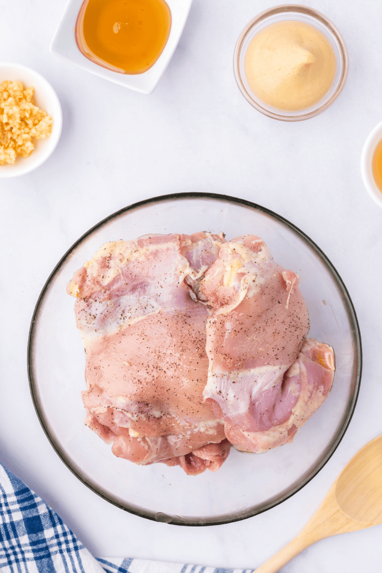 Rub the chicken thighs with olive oil, then season with salt and pepper.