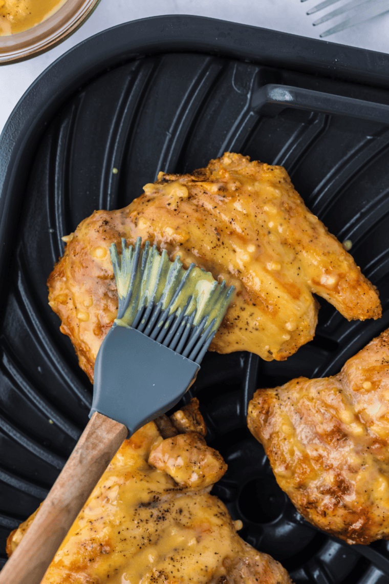 Golden-brown boneless chicken thighs grilled in a Ninja Foodi, served on a plate.