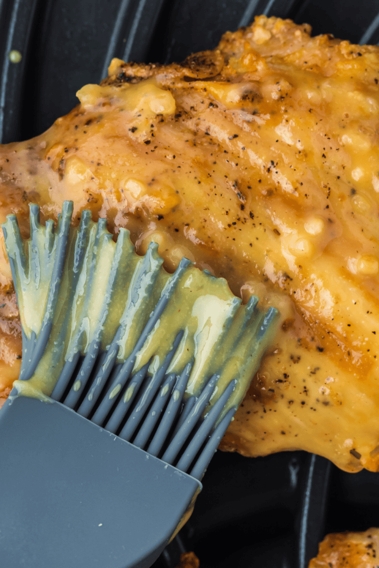 Golden-brown boneless chicken thighs grilled in a Ninja Foodi, ready to serve on a plate.