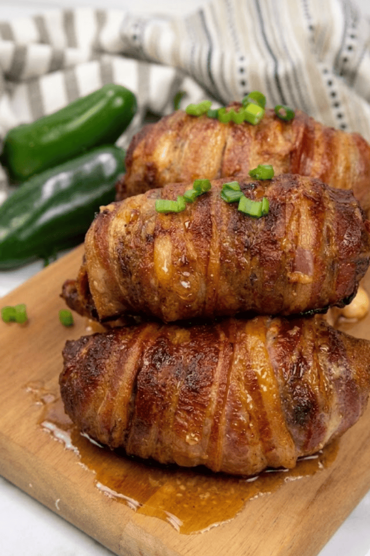 Crispy, bacon-wrapped Air Fryer Armadillo Eggs with melted cheese inside, served on a plate.