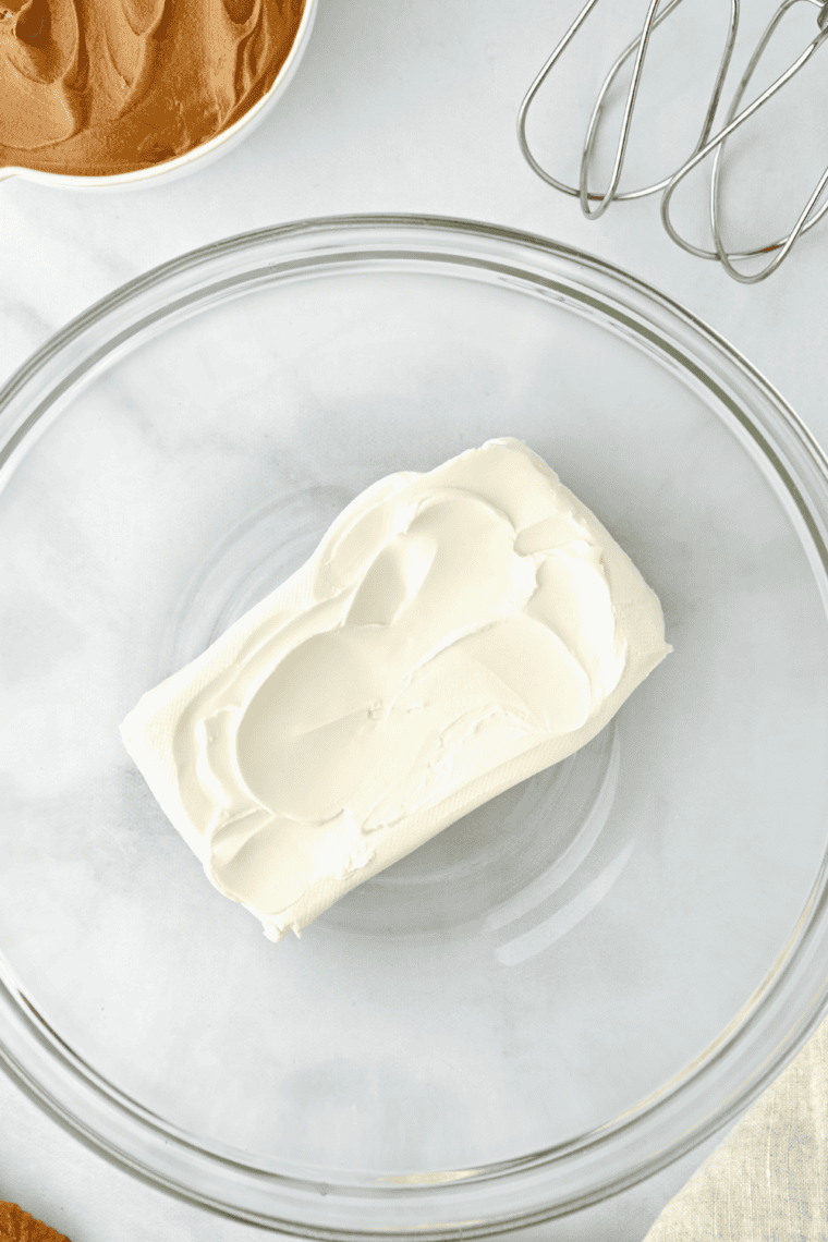 cream cheese being beaten in a bowl until smooth and fluffy