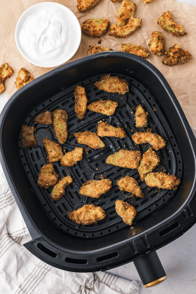 crispy golden air fryer avocado chips served on plate with dipping sauce