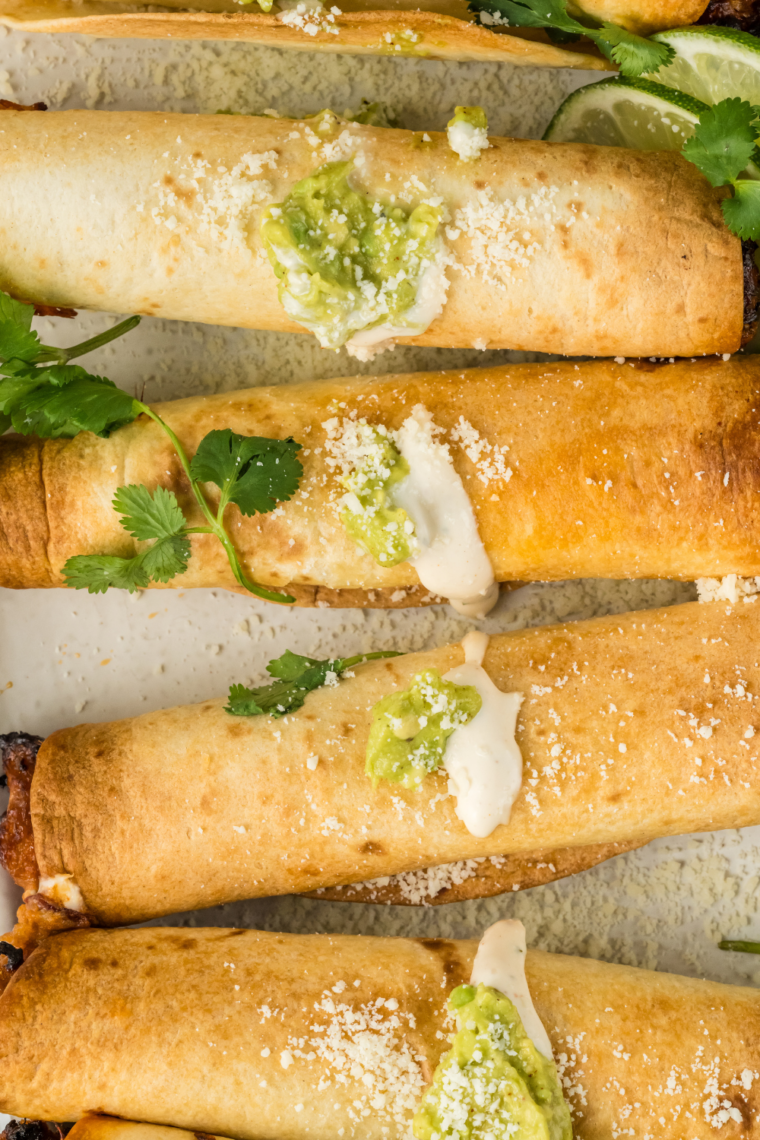 Air fryer hot dog taquitos made with tortillas wrapped around hot dogs, cooked until crispy, golden brown, and cheesy inside.