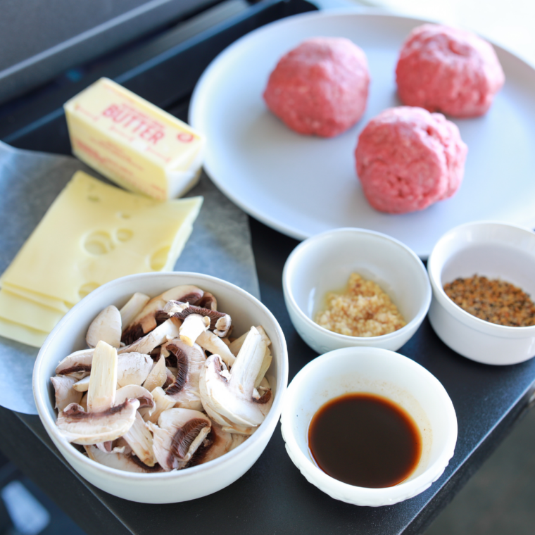 Ground beef divided into loose burger balls on a tray before smashing in cast iron skillet.