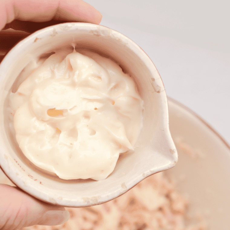Cooked chicken spread out on a plate to cool before shredding, ensuring proper texture and preventing gummy consistency.