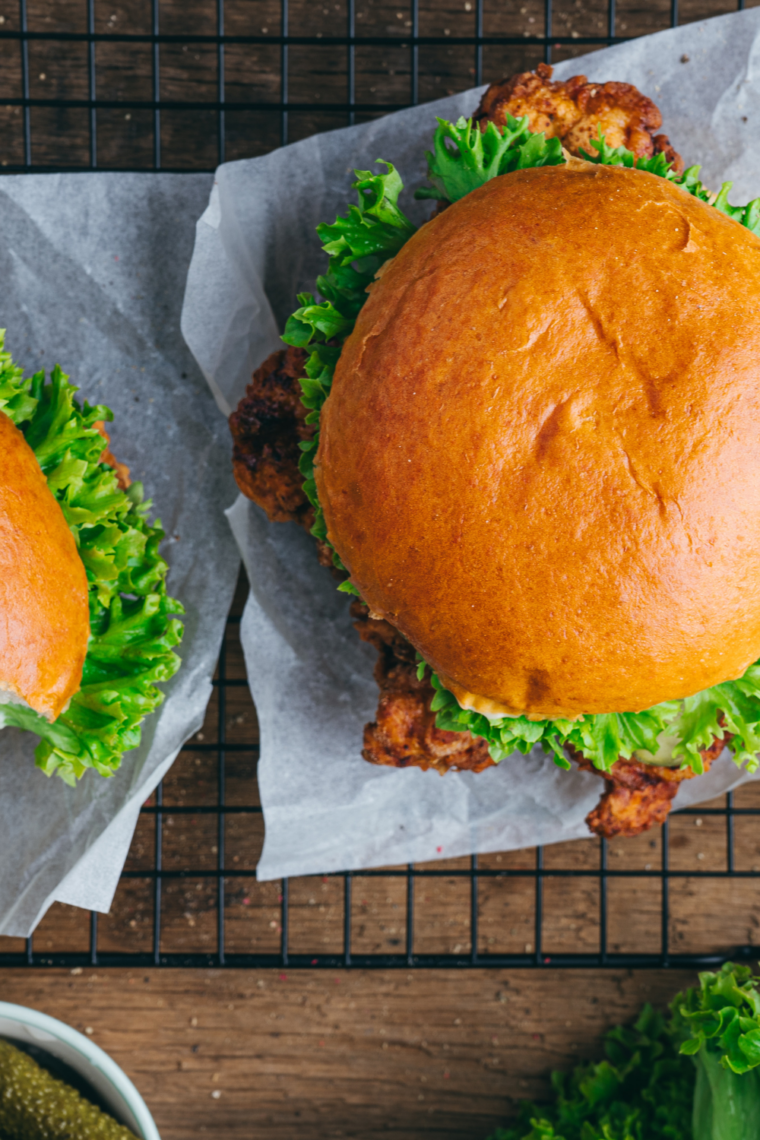 Crispy buttermilk fried chicken breast sandwich with pickles and sauce on a toasted bun, fast food copycat.