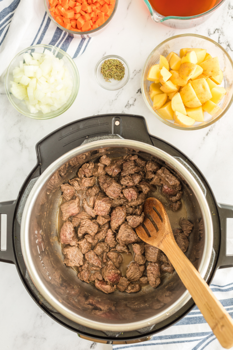 Browning beef chuck in Dutch oven with olive oil for rich stew base flavor