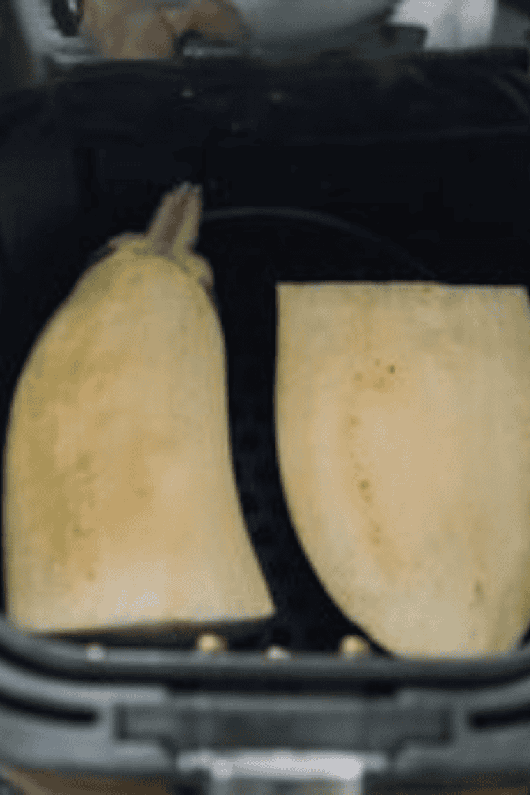 Eggplant halves drizzled with olive oil placed cut-side down on tray