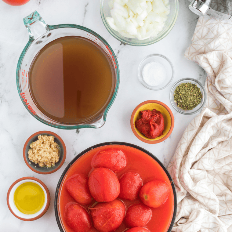 Ingredients needed for Easy Homemade Creamy Tomato Basil Soup (First Watch Copycat) on kitchen table.