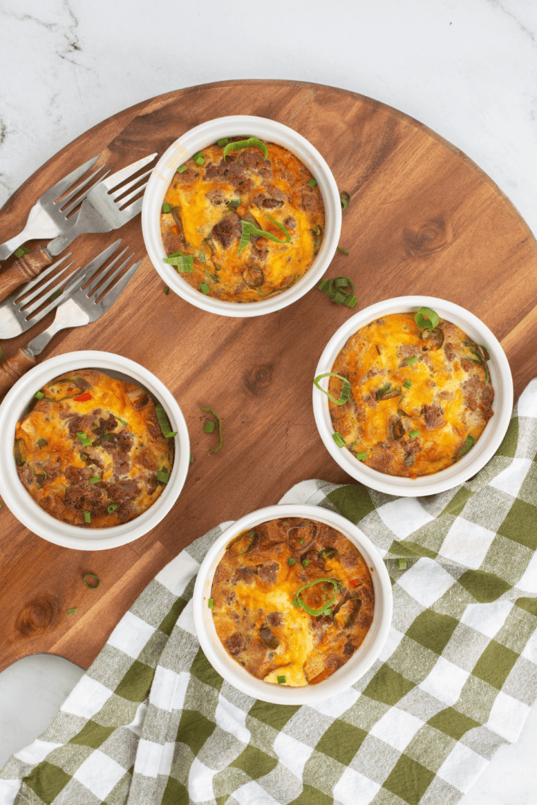 Baked breakfast strata casserole with golden top, layered bread, eggs, cheese, and savory fillings in a glass baking dish.