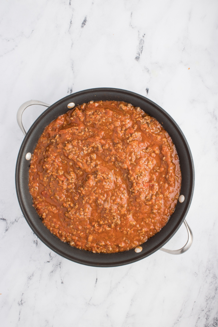Slowly fold in the marinara sauce with the cooked ground beef in a large skillet.