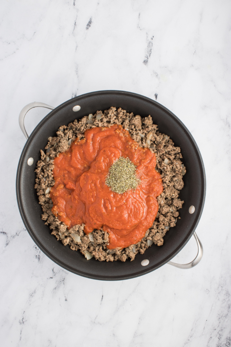 Layered baked spaghetti dish with pasta, meat sauce, and mozzarella cheese.