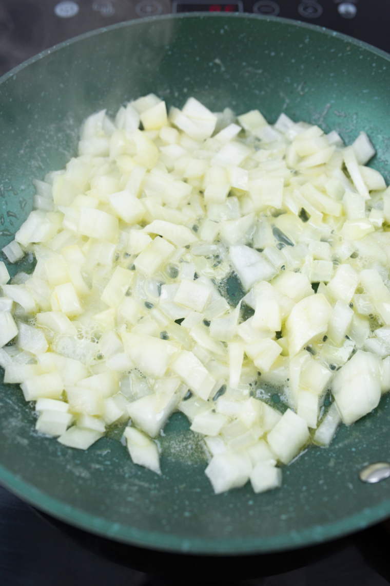 Making homemade Alfredo sauce with butter, garlic, cream, and Parmesan cheese