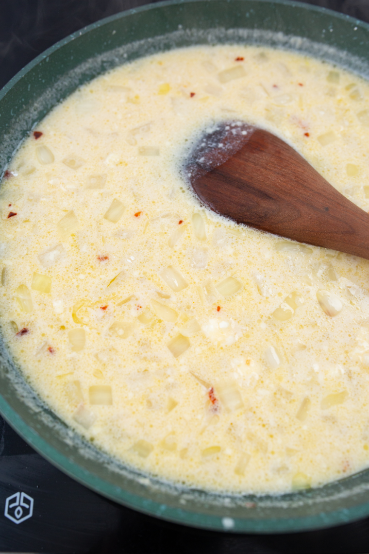 Baked chicken broccoli penne casserole resting and garnished with fresh herbs and Parmesan