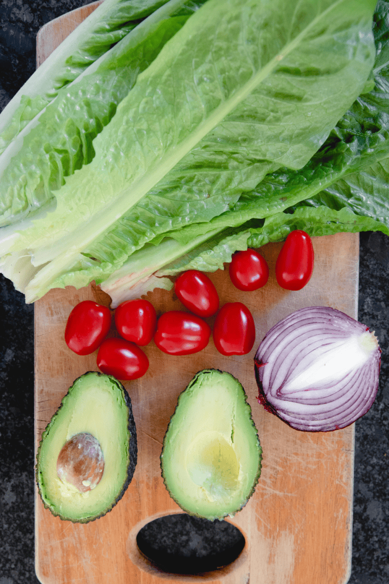 Prepped ingredients with chopped romaine lettuce in large bowl base