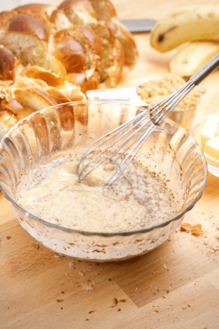 Soaking brioche bread in citrus custard mixture bowl