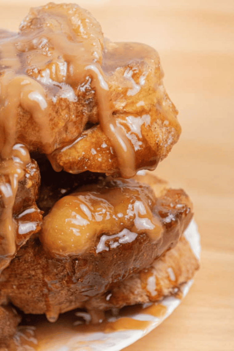 Thick brioche Floridian French toast topped with fresh fruit, powdered sugar, and maple syrup inspired by First Watch brunch presentation on a white plate.