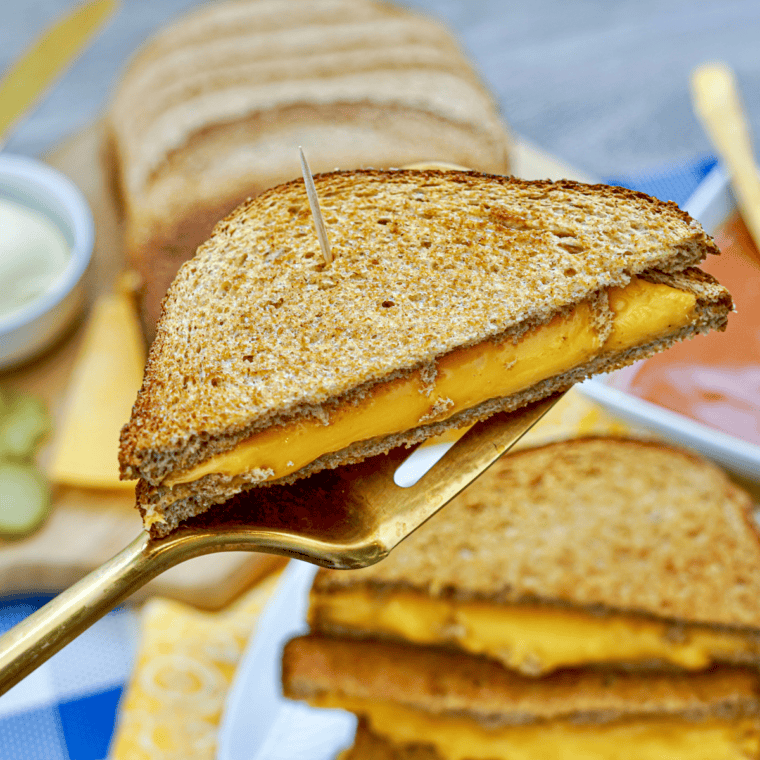 Crispy grilled cheese sandwich made with sourdough bread, golden buttered crust, and melted cheddar and American cheese inside, inspired by First Watch.